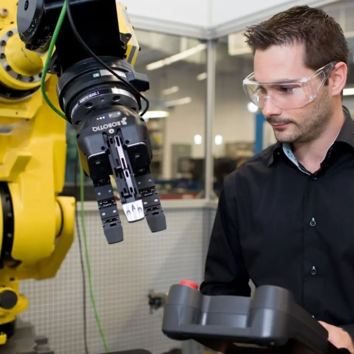 Personne étudiante qui manipule le bras robotique avec une grande console