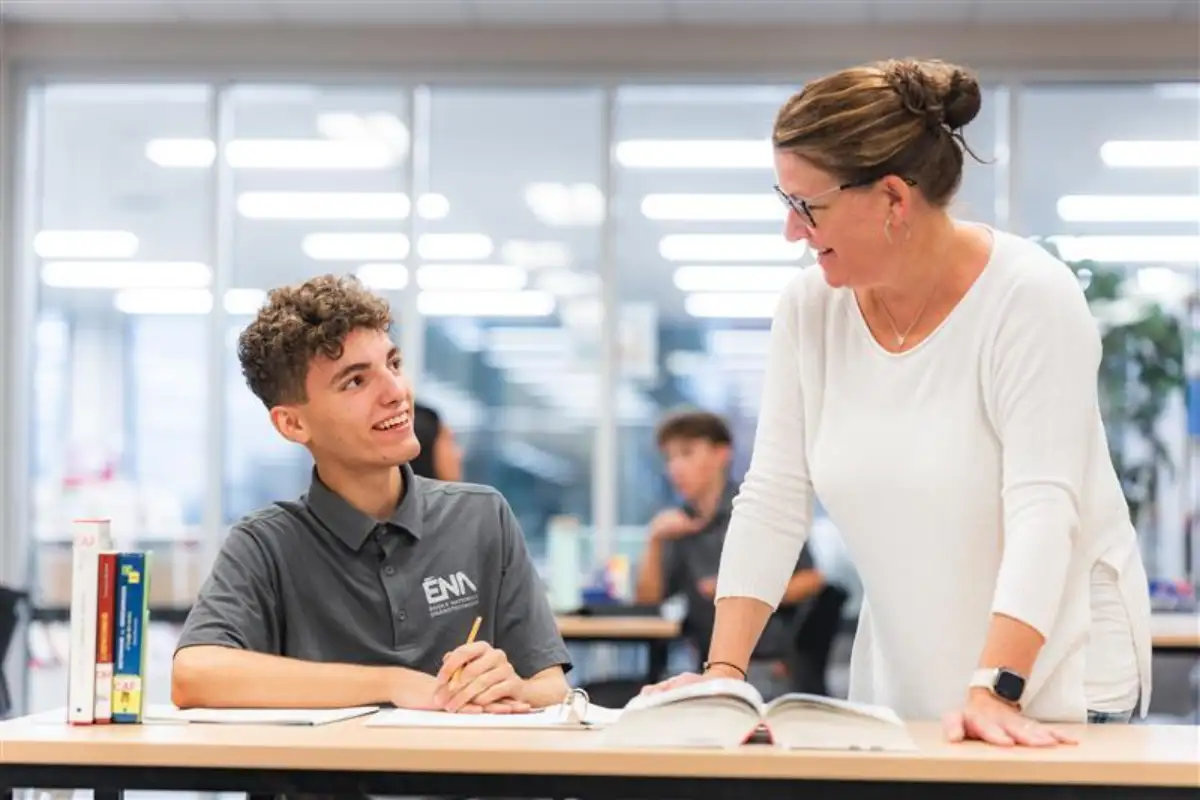 Un étudiant et une personne ressource de la bibliothèque