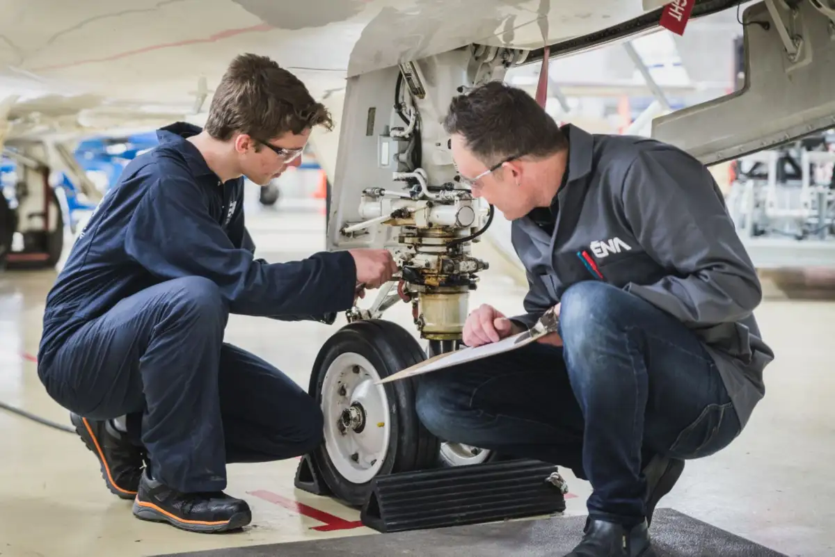 Professeur et son étudiant devant un avion