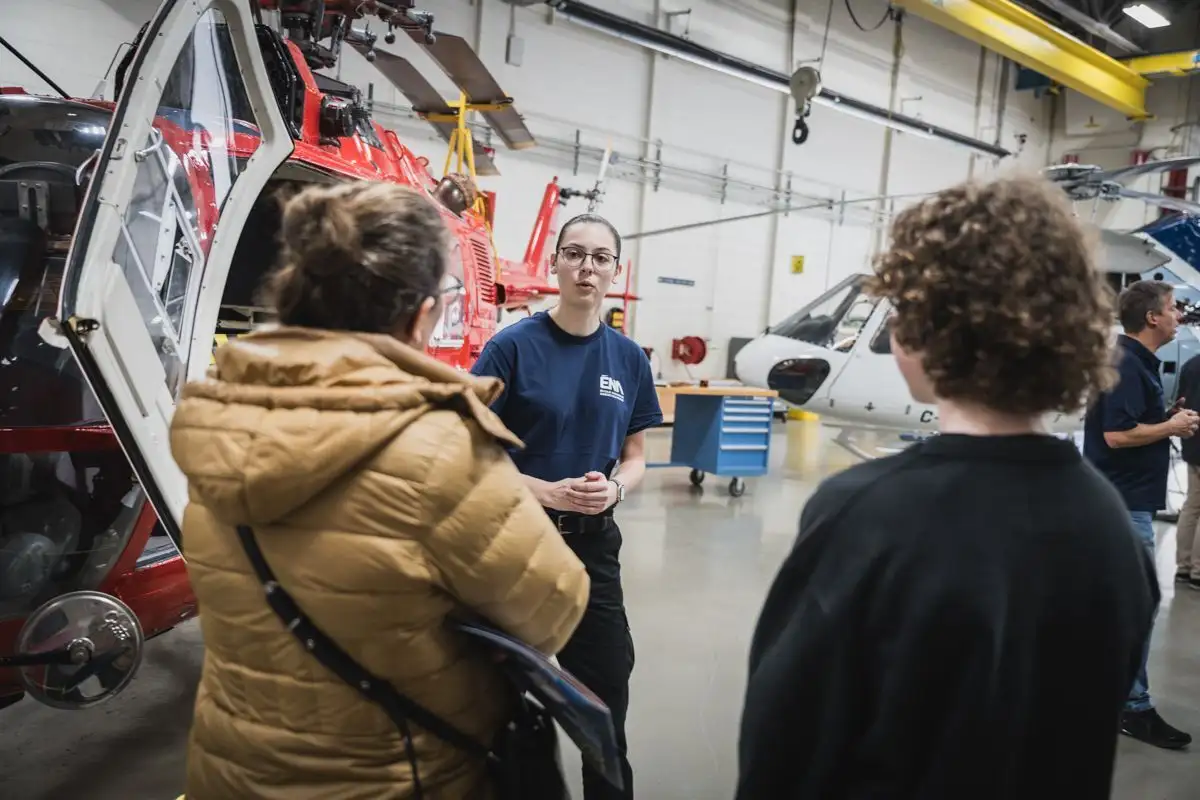Étudiante donnant des explications devant un hélicoptère