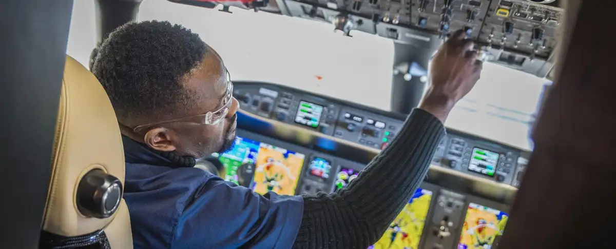 Un homme dans un cockpit d'avion qui observe les boutons de contrôle