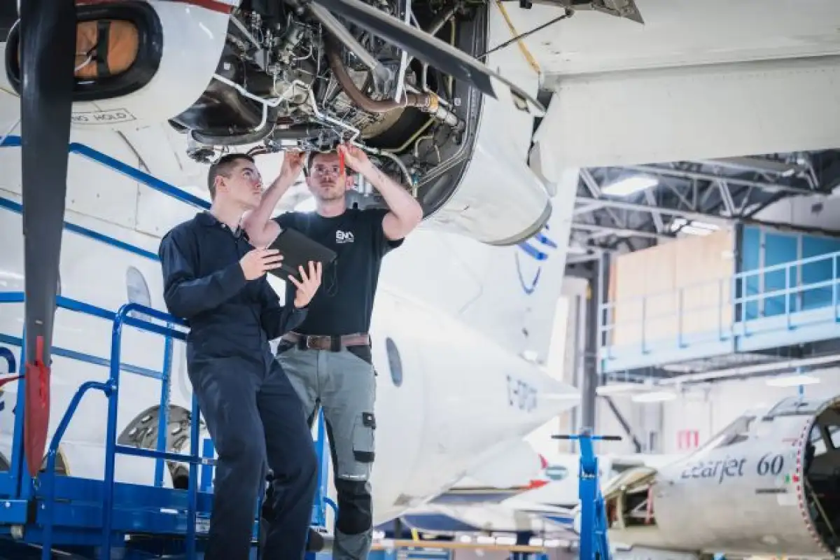 Étudiants qui inspectent un moteur d'avion