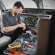 Étudiant retirant un composant dans un cockpit d'avion