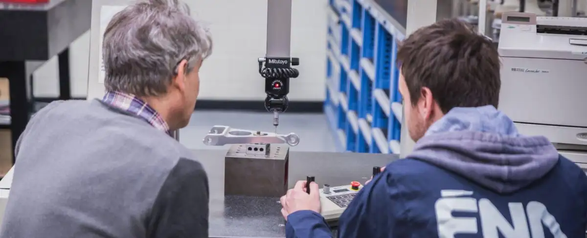 Deux hommes qui regardent une pièce d'équipement dans un laboratoire