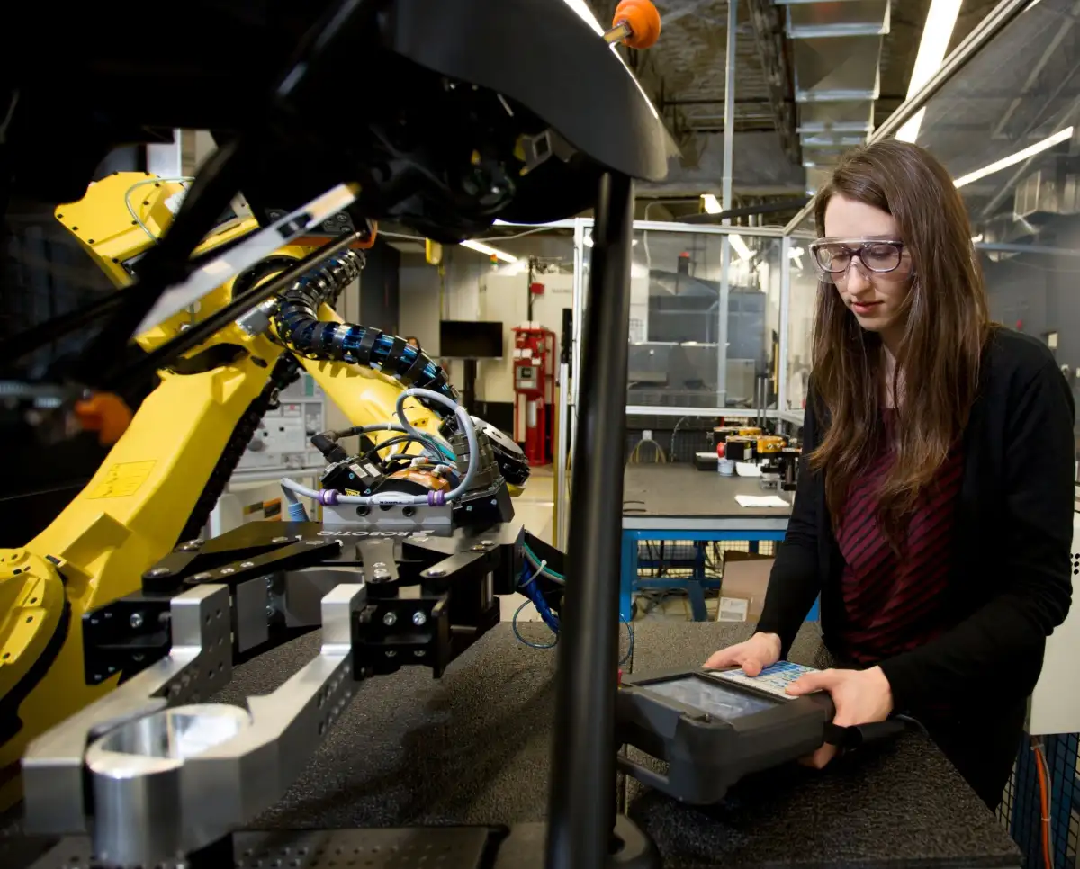 une étudiante qui contrôle un robot