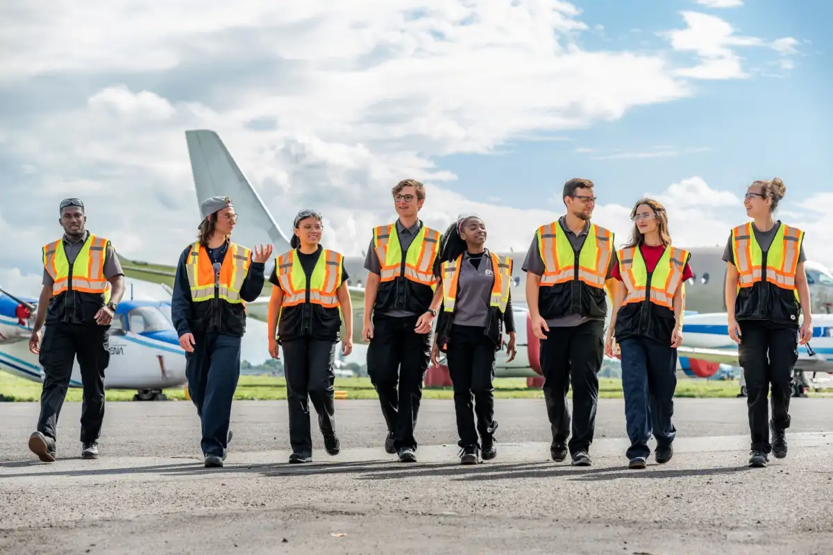 Étudiants marchant sur le tarmac, devant un Airbus A220
