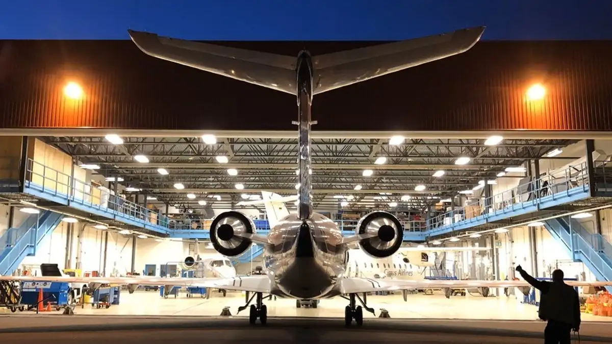 Avion devant un hangar, de nuit