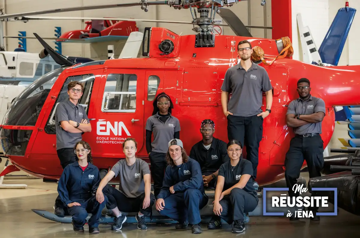 Personnes étudiantes devant un hélicoptère dans un hangar de l'ÉNA