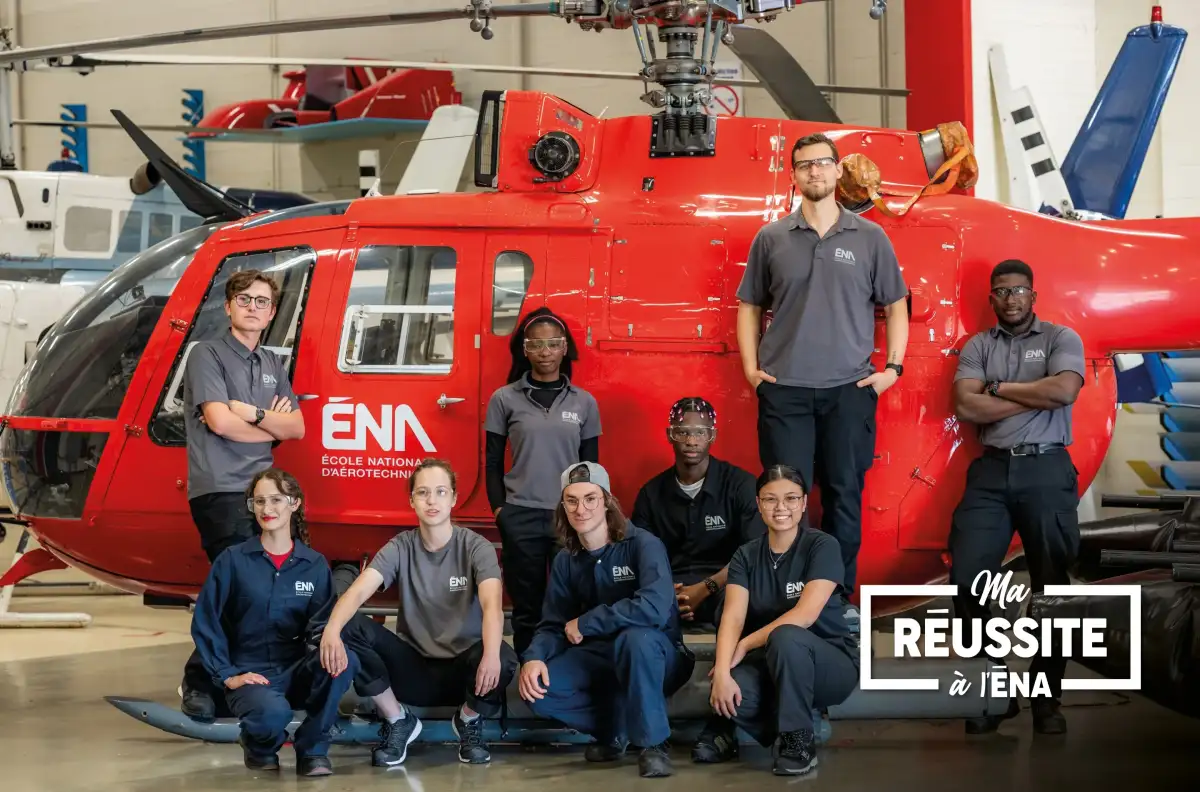 Personnes étudiantes devant un hélicoptère dans un hangar de l'ÉNA