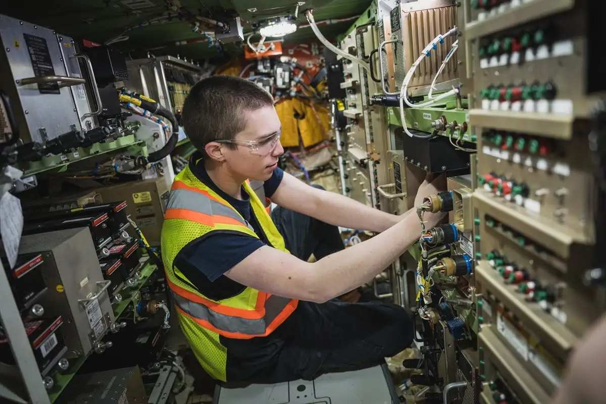 Etudiant dans la baie avionique d'un avion