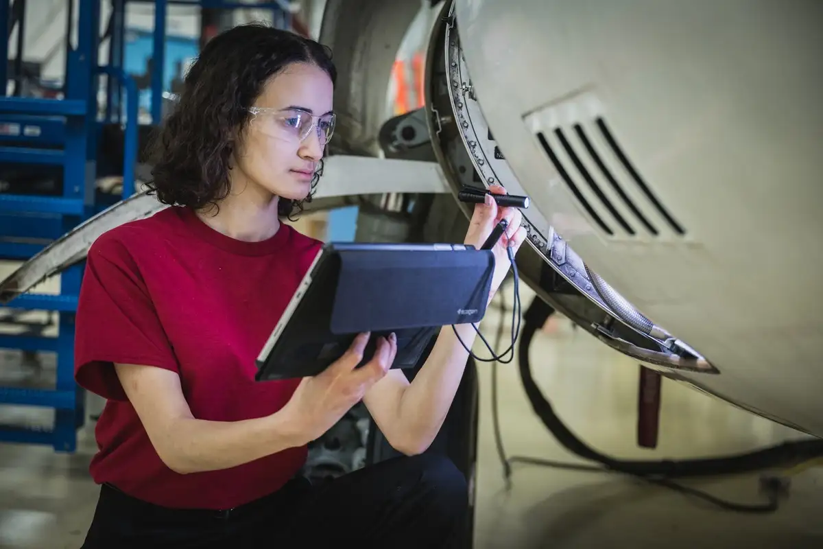 Etudiante inspectant un fuselage