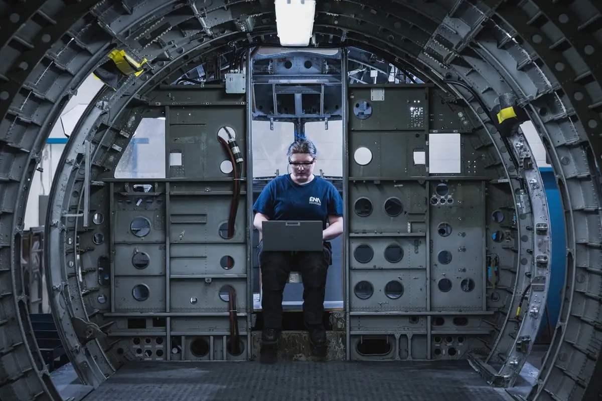 Etudiante consultant un ordinateur portatif dans un fuselage