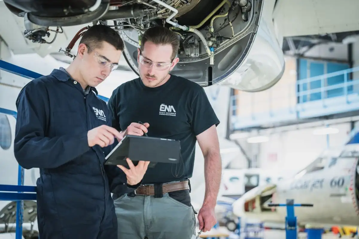 Etudiants inspectant un moteur d'avion dans un hangar